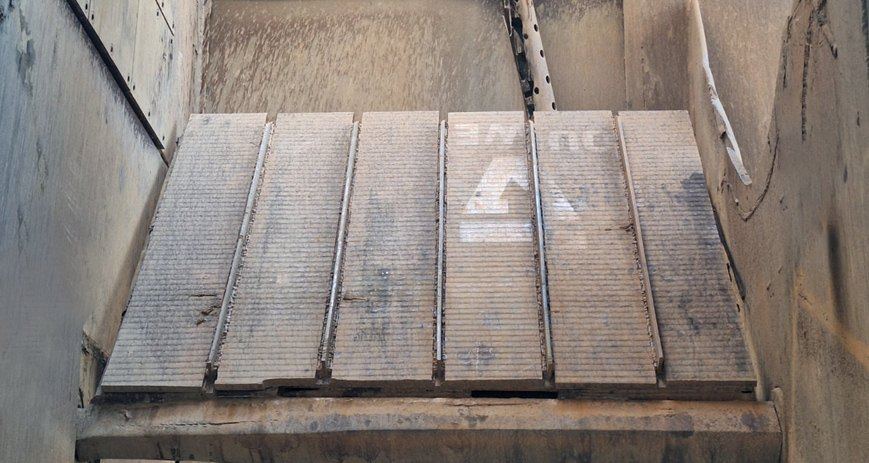 Overlay-lined coal chute in a power plant